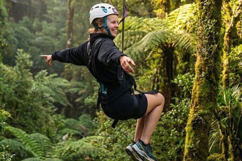 A person zip-lining through a forest. 2