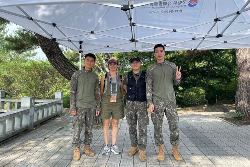 Four people standing under a tent in a park. 1