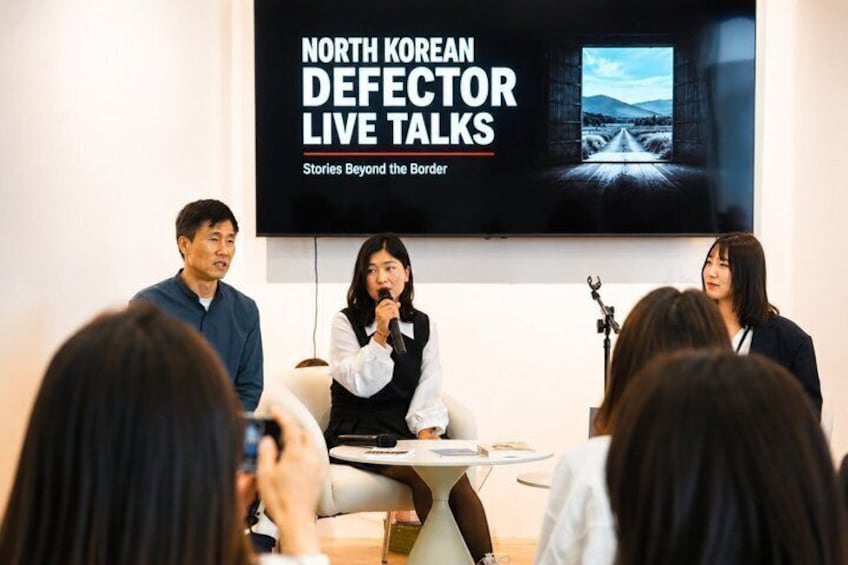 A panel discussion with a screen displaying 'NORTH KOREAN DEFECTOR LIVE TALKS Stories Beyond the Border' in the background. 4