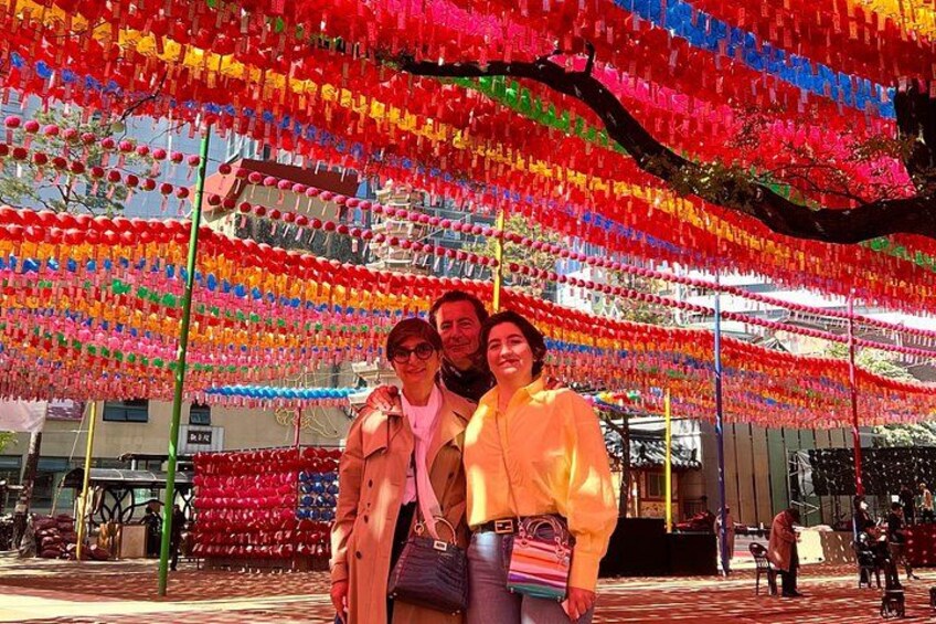 A street with colorful hanging decorations and a tree in the background. 4