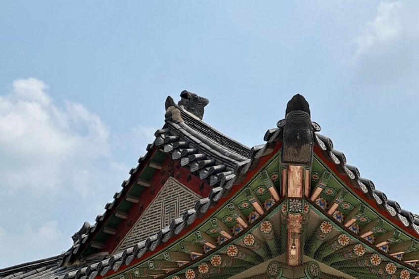 A traditional Korean roof with ornate decorations and a clear blue sky. 2