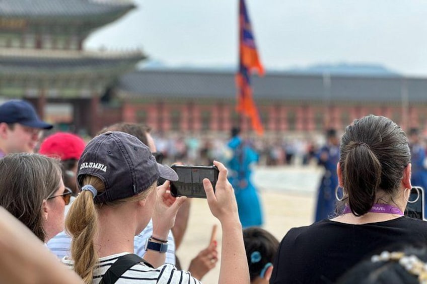 A crowd of people at a historical site with traditional architecture. 5