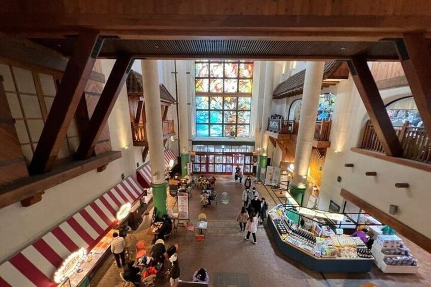 An indoor market with wooden beams, a central display, and people browsing. 4