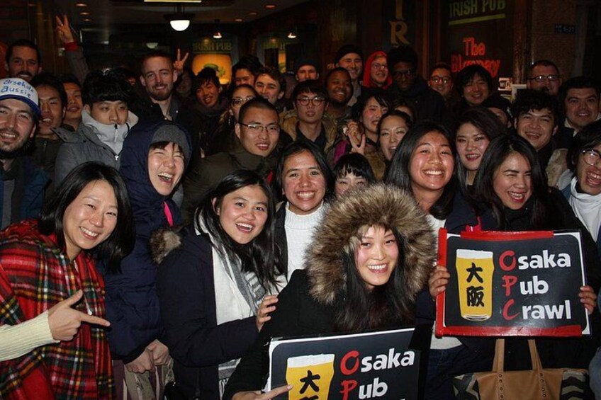 A group of people holding signs for Osaka Pub. 4