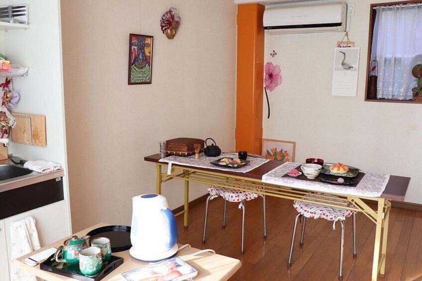 Un comedor con una mesa dispuesta para dos personas, una tetera, tazas y un cebrero. 2