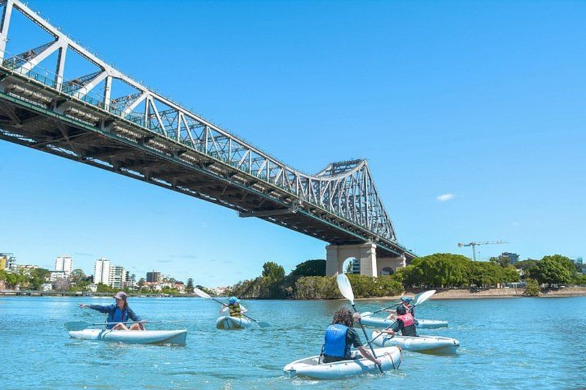 People kayaking under a bridge. 5