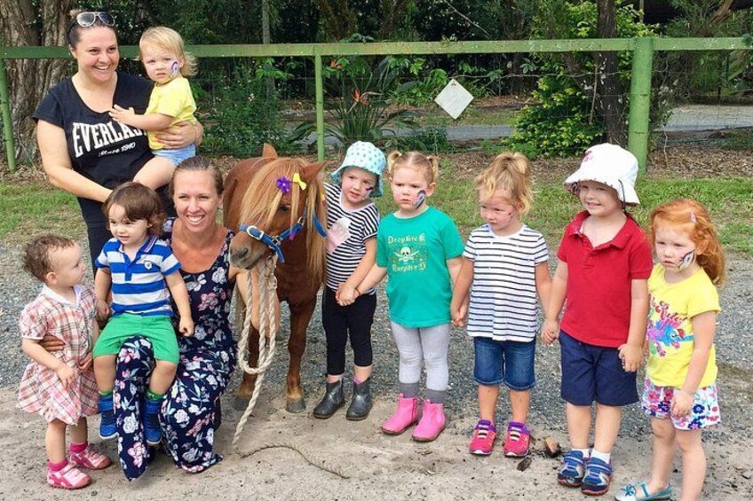 A group of people with a horse in a fenced outdoor area. 2