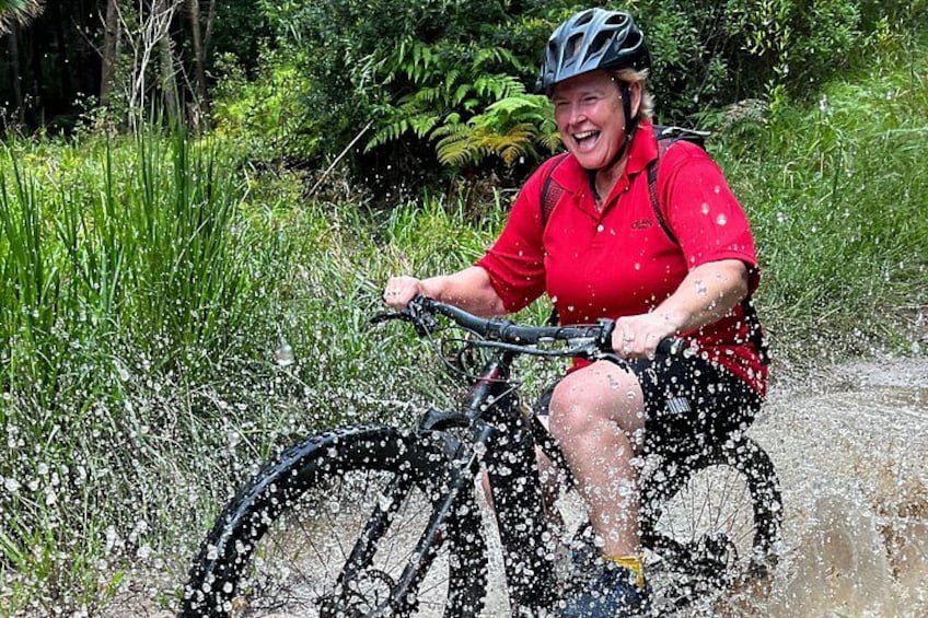 A person riding a bicycle through a shallow water crossing. 2