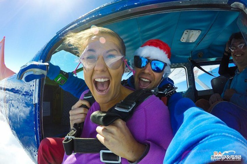A person in a purple shirt and red pants inside a vehicle with a blue interior. 5