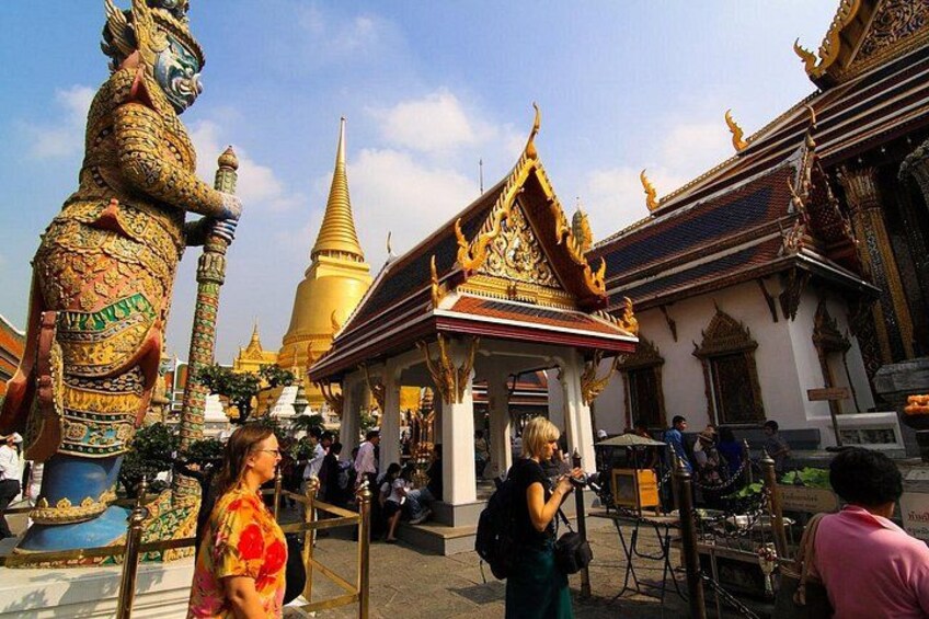 A temple with ornate architecture, a golden stupa, and a large statue. 5