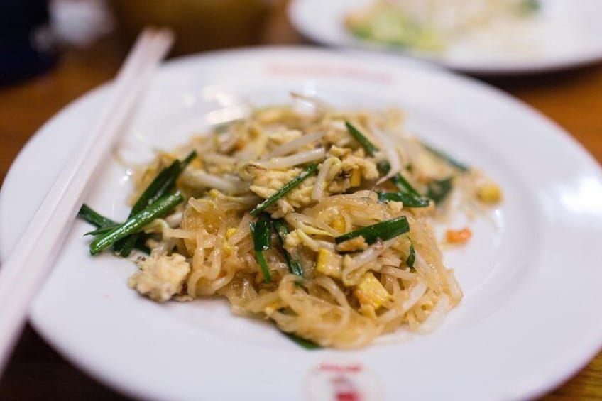 A plate of stir-fried noodles with vegetables and scrambled eggs. 3