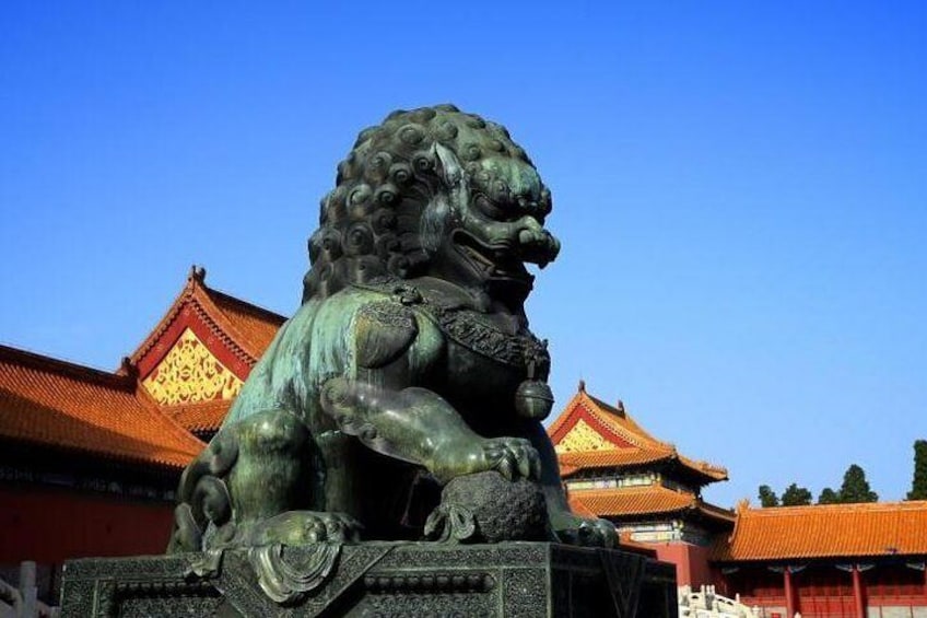 A bronze lion statue in front of traditional Chinese architecture. 4