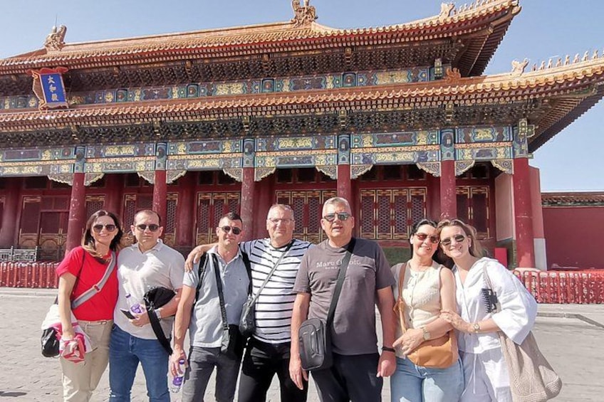 A group of people in front of a traditional Chinese building with ornate architecture. 2