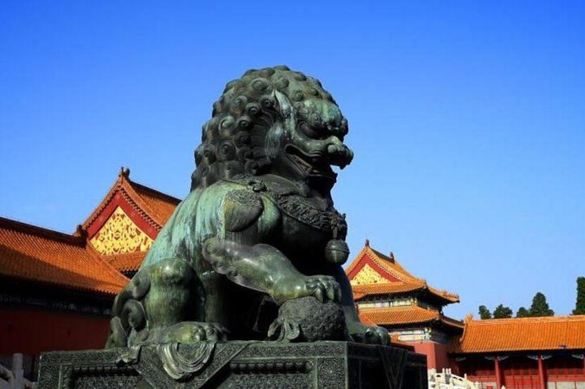 Una estatua de bronce de un león frente a una arquitectura china tradicional. 5