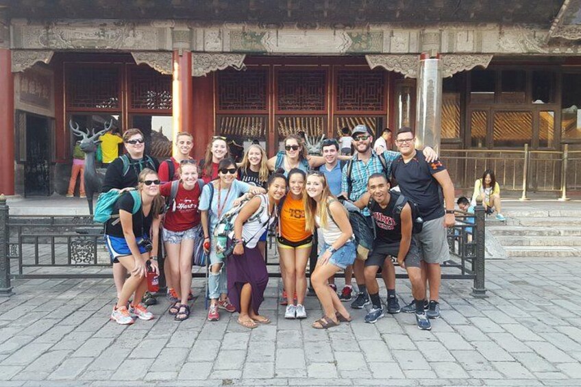 A group of people posing in front of a traditional building with ornate architecture. 2