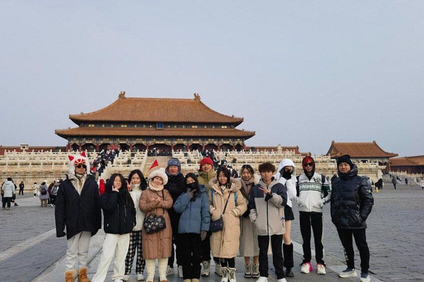 A group of people posing in front of a traditional Chinese building with a tiled roof. 2