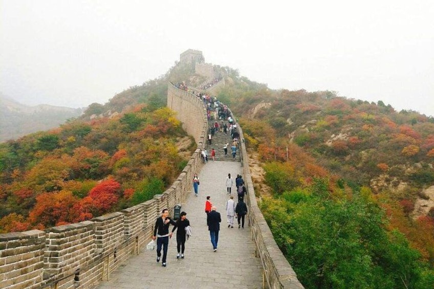 The Great Wall of China, a long stone wall with watchtowers, winding through a mountainous landscape with autumn foliage. 3