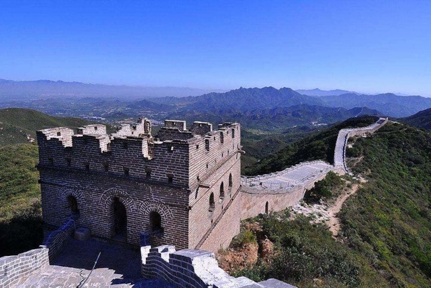 The Great Wall of China, a historical landmark, with a clear view of its ancient architecture and the surrounding mountainous landscape. 4