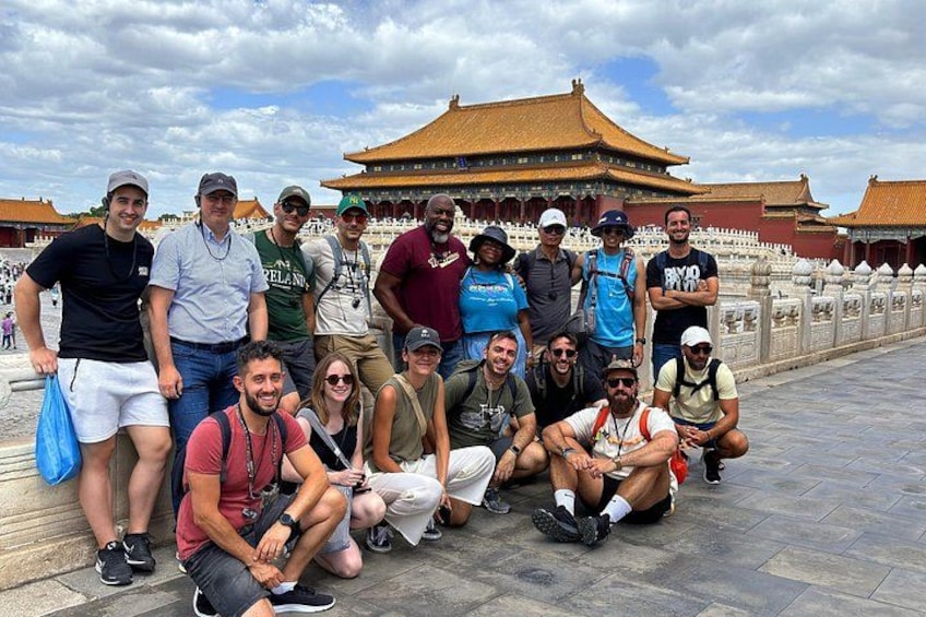 A group of people posing in front of a traditional Chinese building with a golden roof. 3