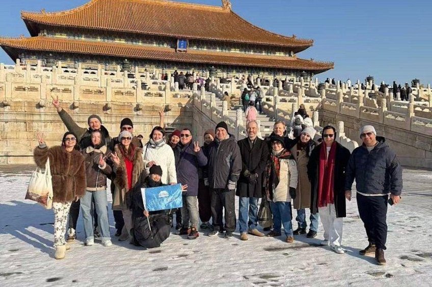 A group of people posing in front of a traditional Chinese building with a tiled roof. 4
