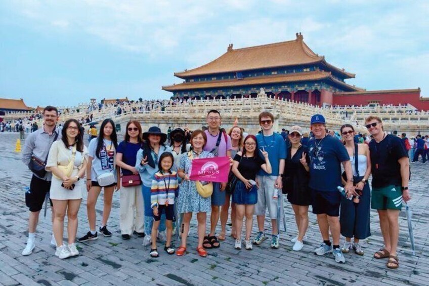 A group of people posing in front of a traditional Chinese building with a tiled roof and a large open courtyard. 5