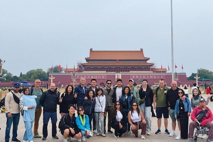 A group of people posing in front of a traditional Chinese building with a red roof and white walls. 2