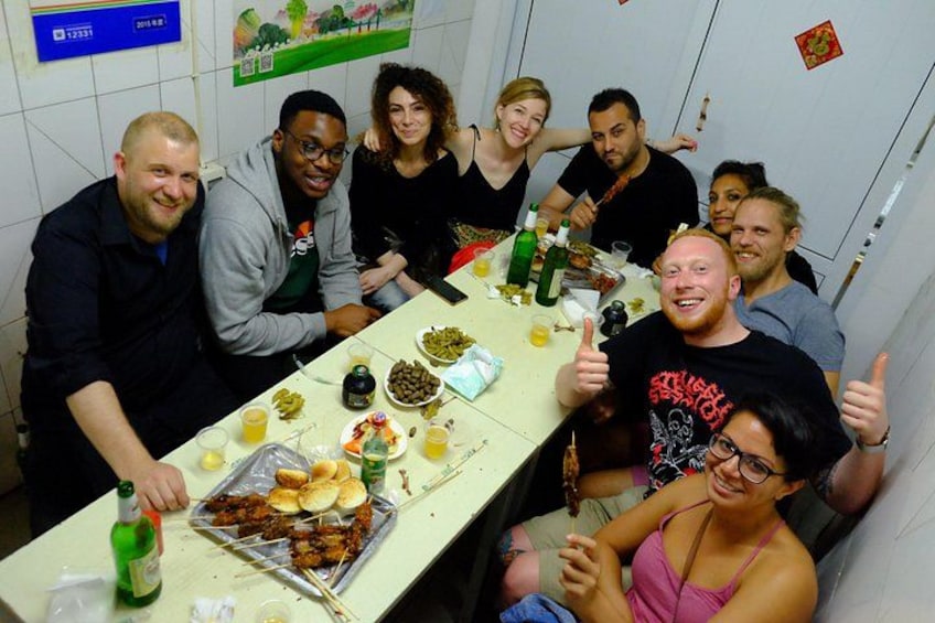 A group of people around a table with food and drinks. 2