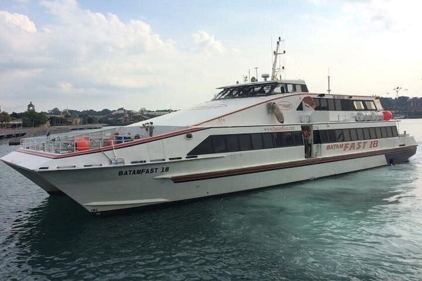 A large white boat named BATANFAST 18 docked at a harbor with calm water and a clear sky. 4