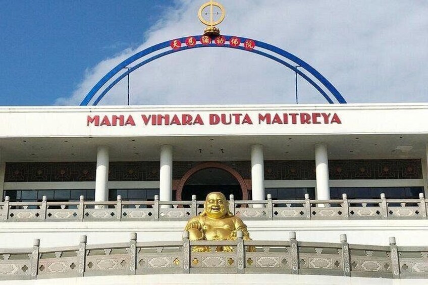 A building with a large golden statue in front, and the text 'MAHA VINARA DUTA MAITREYA' above the entrance. 5