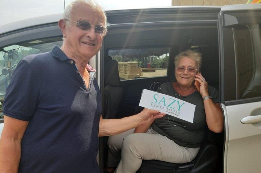 A man and a woman in a vehicle with a sign reading 'SAZY LANKA TOURS.' 4