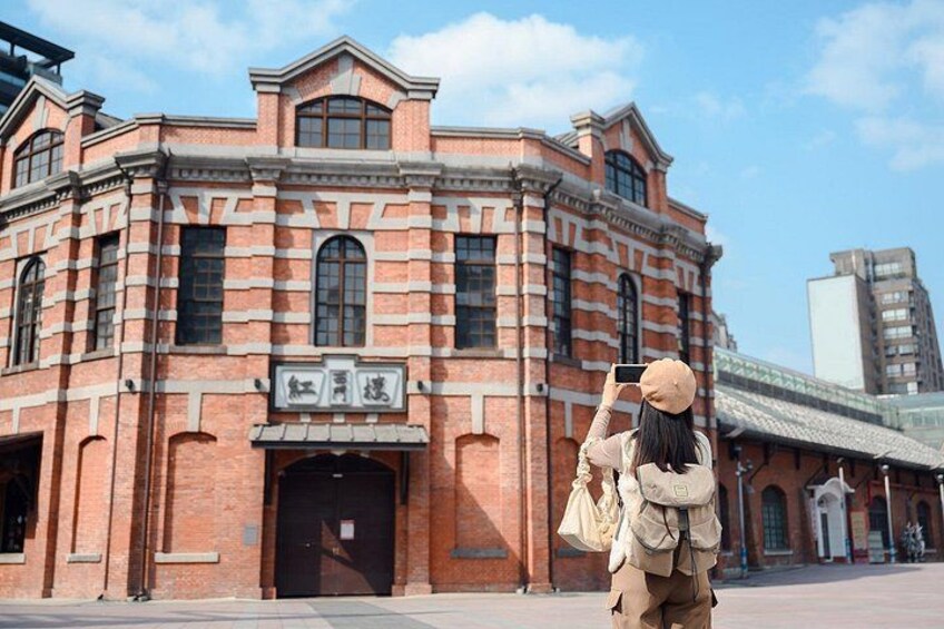 A brick building with arched windows and a sign with Chinese characters. 3