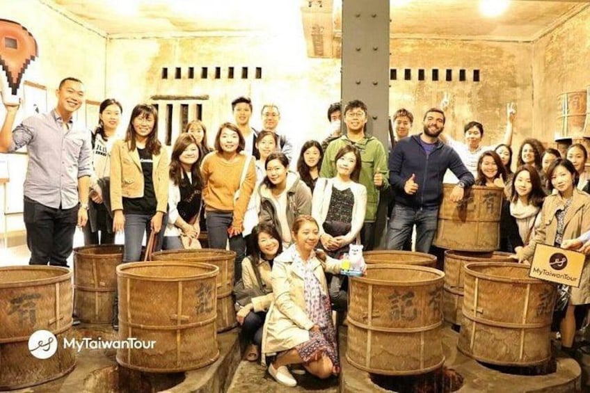 A group of people in a room with wooden barrels. 2