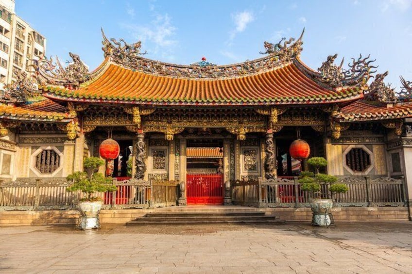A traditional Chinese temple with ornate architecture, a red gate, and two red lanterns. 4