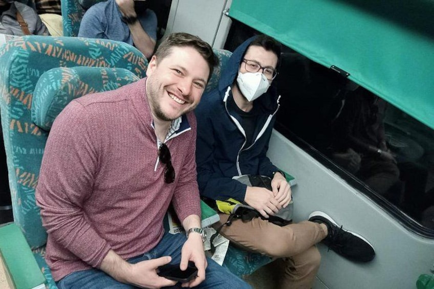 Dos personas sentadas en un tren, una sosteniendo un teléfono inteligente. 5