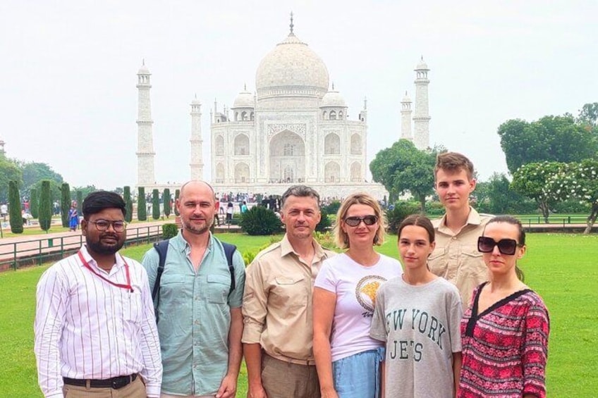 A group of people standing in front of the Taj Mahal. 1