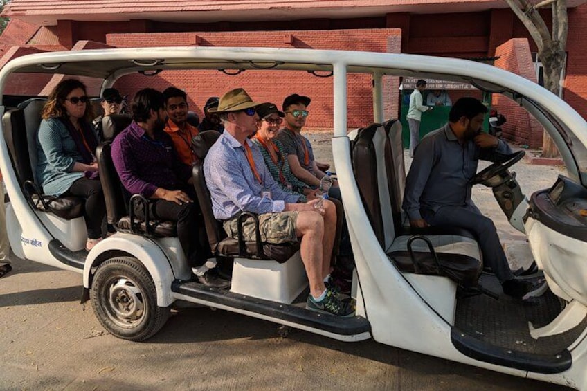 A white three-wheeled vehicle with passengers. 4