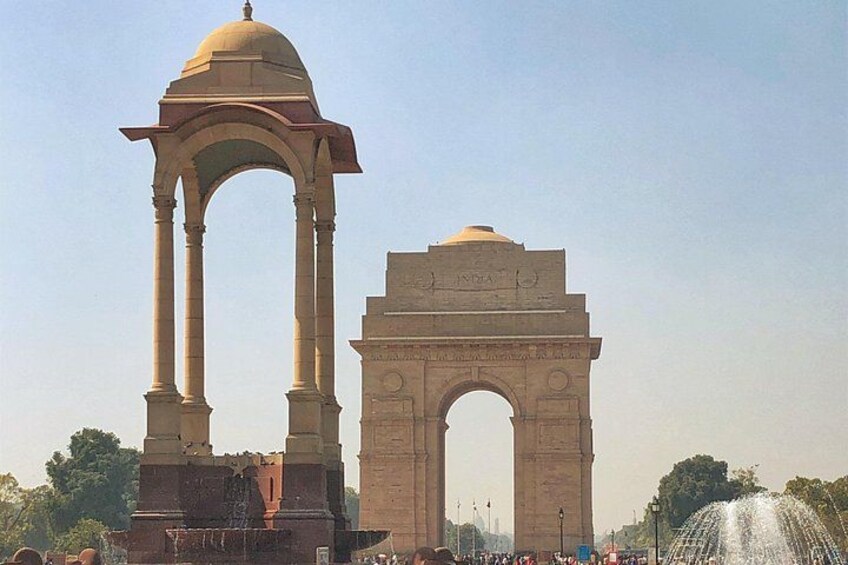 The India Gate monument, a large stone archway with a dome, and a fountain in the foreground. 4