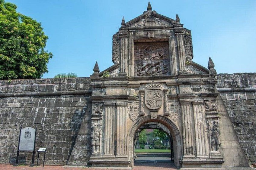 An ancient stone gate with intricate carvings and a central archway. 1