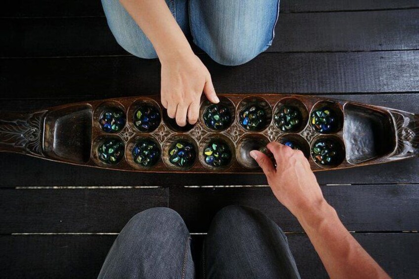 Una persona jugando a canicas sobre un tablero de madera. 1