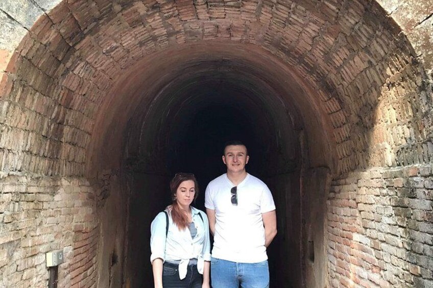 Un hombre y una mujer de pie en un túnel de ladrillo. 1