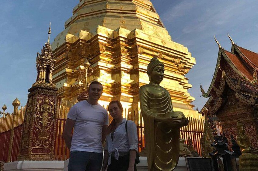 Una estupa dorada con una gran estatua de Buda en primer plano, rodeada de arquitectura ornamentada. 5