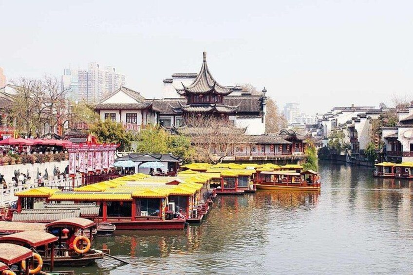A traditional river scene with boats and buildings. 1
