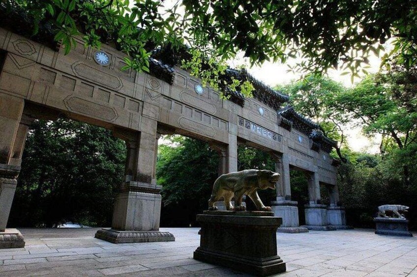 A stone bridge with a bear statue in a park. 3