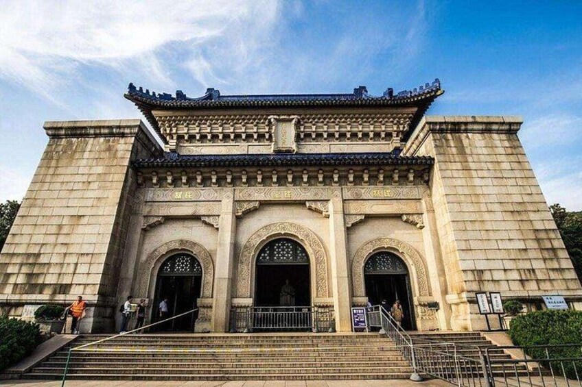 A traditional building with a tiled roof, large arched entrance, and steps leading up to it. 4
