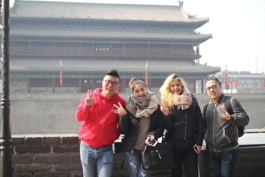A group of people posing in front of a traditional Chinese building with a multi-tiered roof. 1