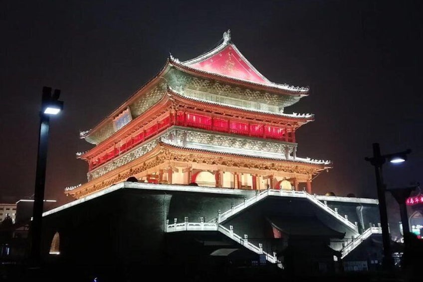 A traditional multi-tiered building with illuminated red and white sections, likely a historical or cultural landmark. 5