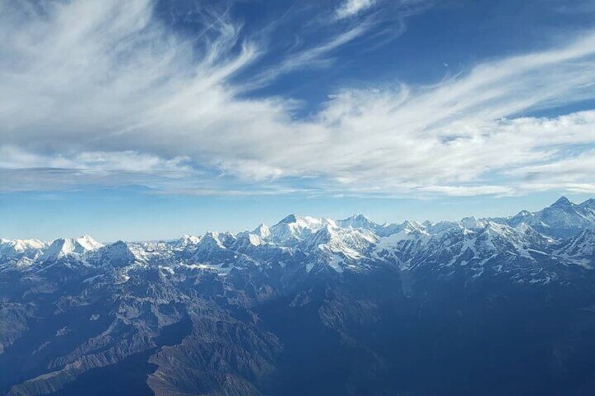 Une chaîne de montagnes enneigées sous un ciel partiellement nuageux. 1