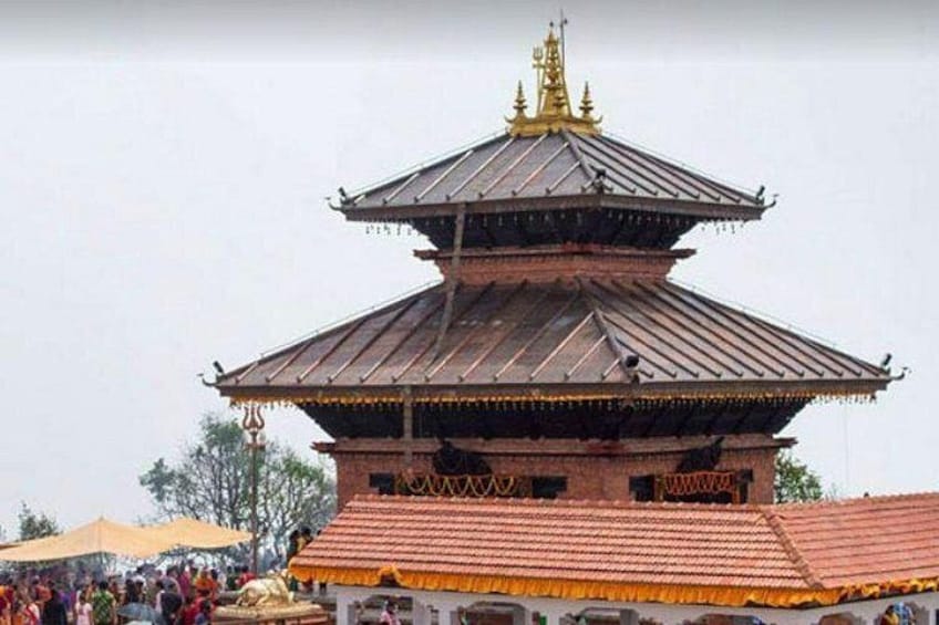 A traditional multi-tiered temple with a golden spire, surrounded by a crowd. 2