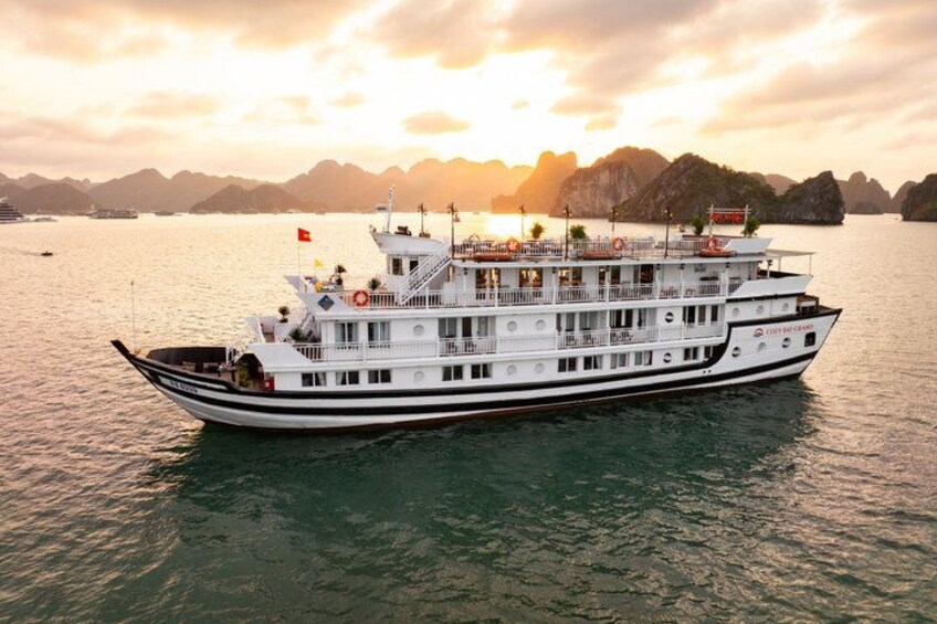 A large white river cruise ship with multiple decks and a flag, sailing on a calm river with mountains in the background. 1