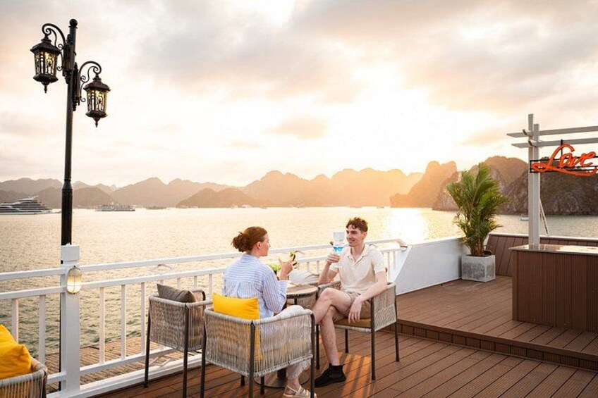 Two people sitting on a deck with a view of a body of water and mountains in the background. 4